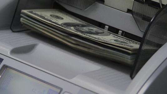 点钞机在银行票据柜台计算100美元钞票和纸币视频的预览图