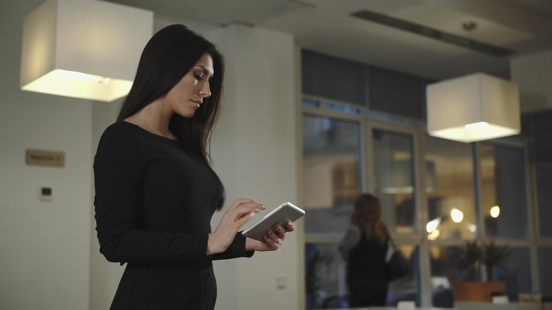 女性商业女性站在办公室与平板电脑交谈视频的预览图