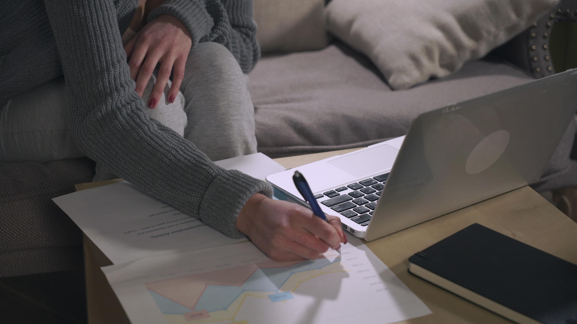 女性用手在图表和笔记本电脑上做笔记视频的预览图