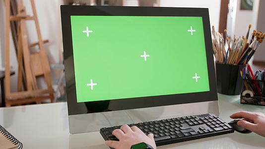 男性在绿屏前键盘上打字视频的预览图