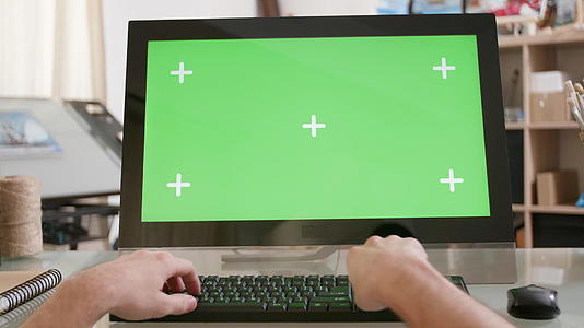 男性手在绿色屏幕前键盘上打字视频的预览图