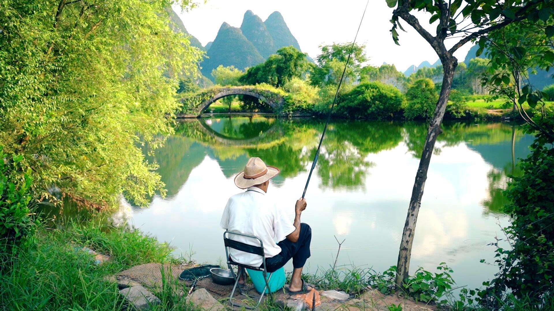 农村老人在山水田野间钓鱼视频的预览图