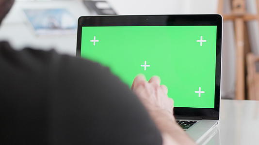 男子在笔记本电脑上用绿色屏幕显示器工作视频的预览图