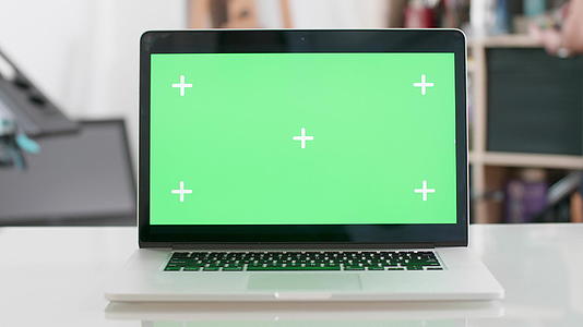 绿色屏幕显示在笔记本电脑的模糊背景上视频的预览图