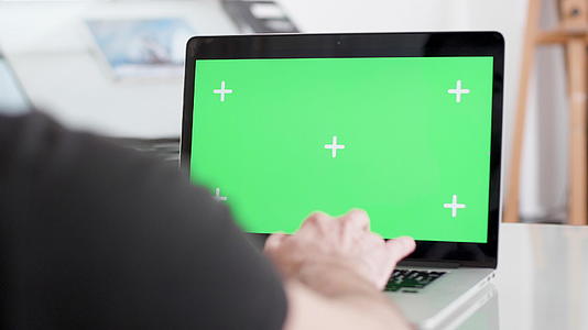 一个在办公室笔记本电脑上工作的人的肩膀中弹视频的预览图