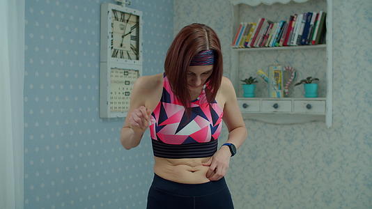 30多岁的年轻女性穿着运动服对肥胖的腹部不满意视频的预览图