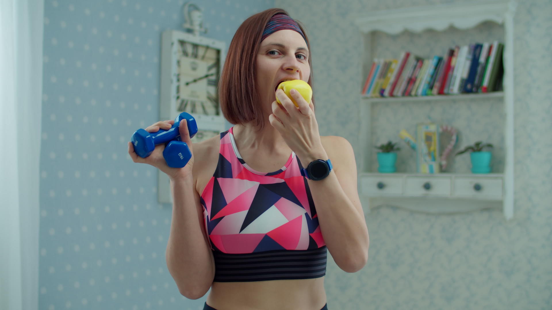 30多岁的年轻女性穿着运动服手里拿着苹果水果手里拿着哑铃视频的预览图