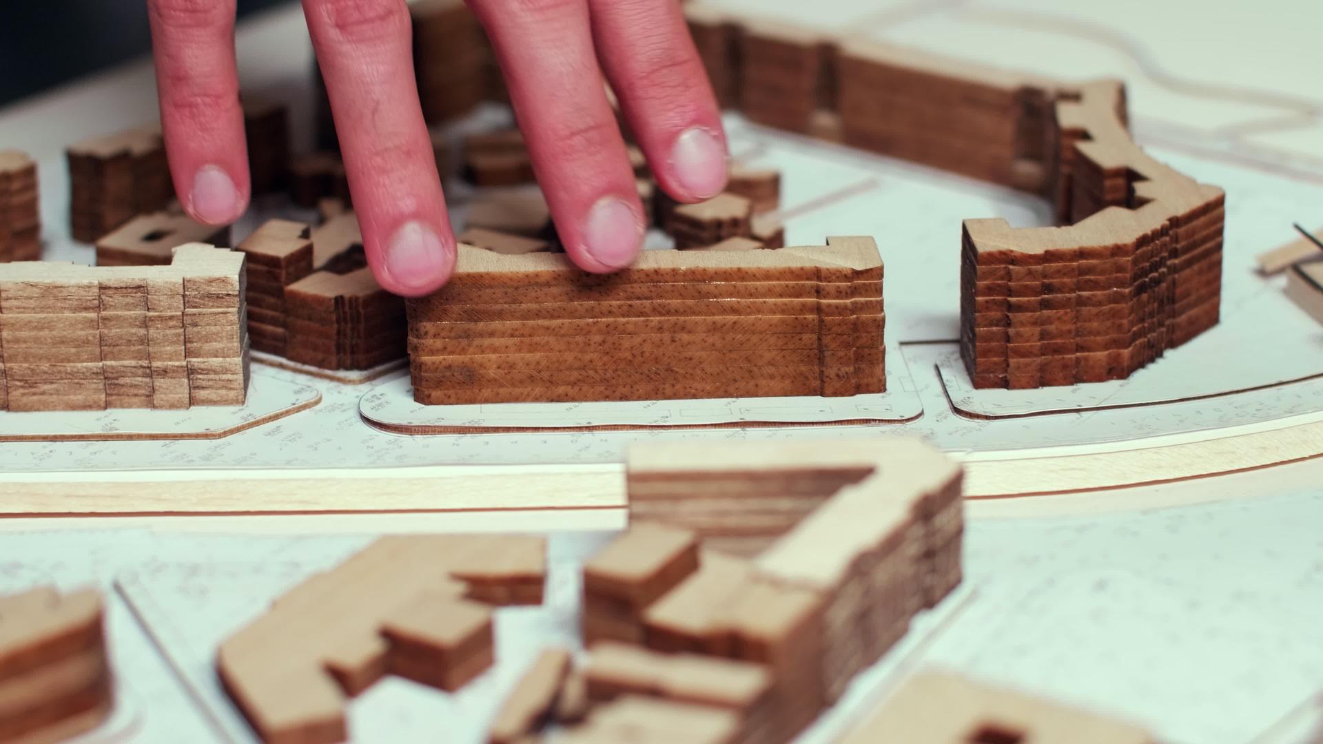 建筑师的手在城市模型上移动视频的预览图