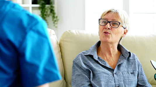 老年妇女坐在疗养院的沙发上与医生交谈视频的预览图
