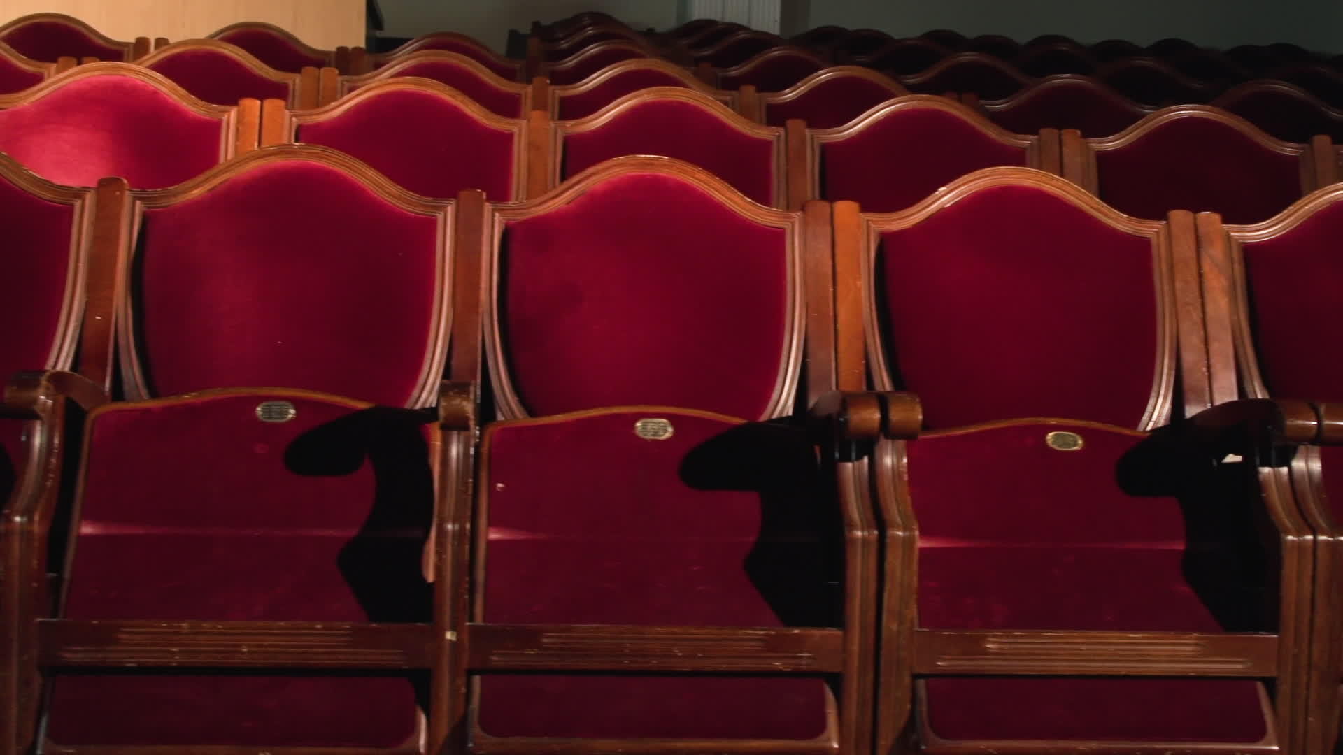在空荡荡的剧院大厅里红色天鹅绒椅子被聚光灯照亮视频的预览图