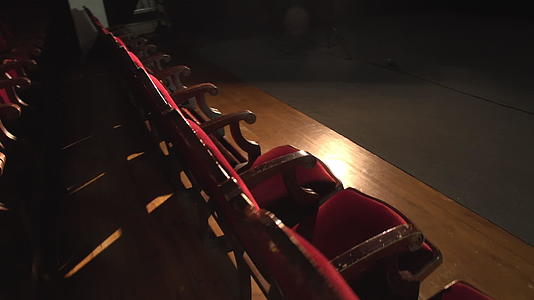 红色天鹅绒木座的后光镜照在剧院的照明上视频的预览图