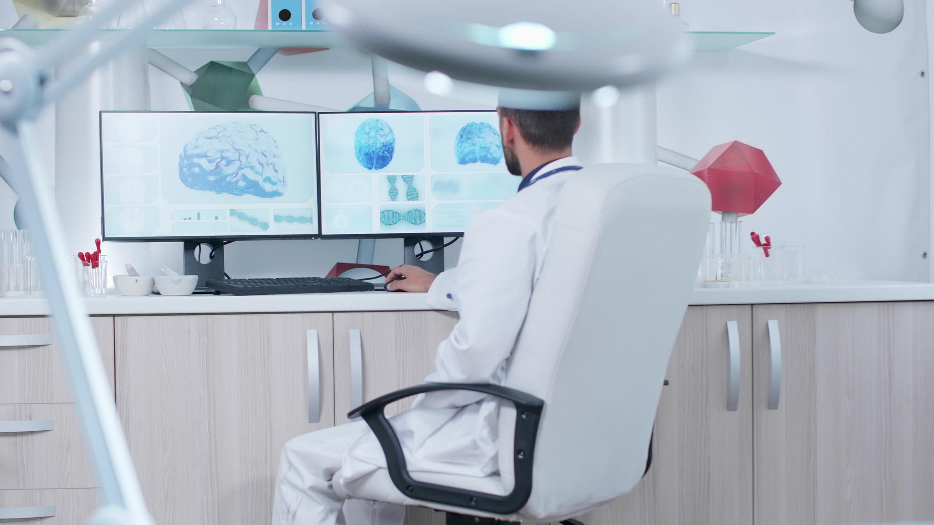 在现代研究设施工作的医生在监视器上显示3D脑扫描仪视频的预览图
