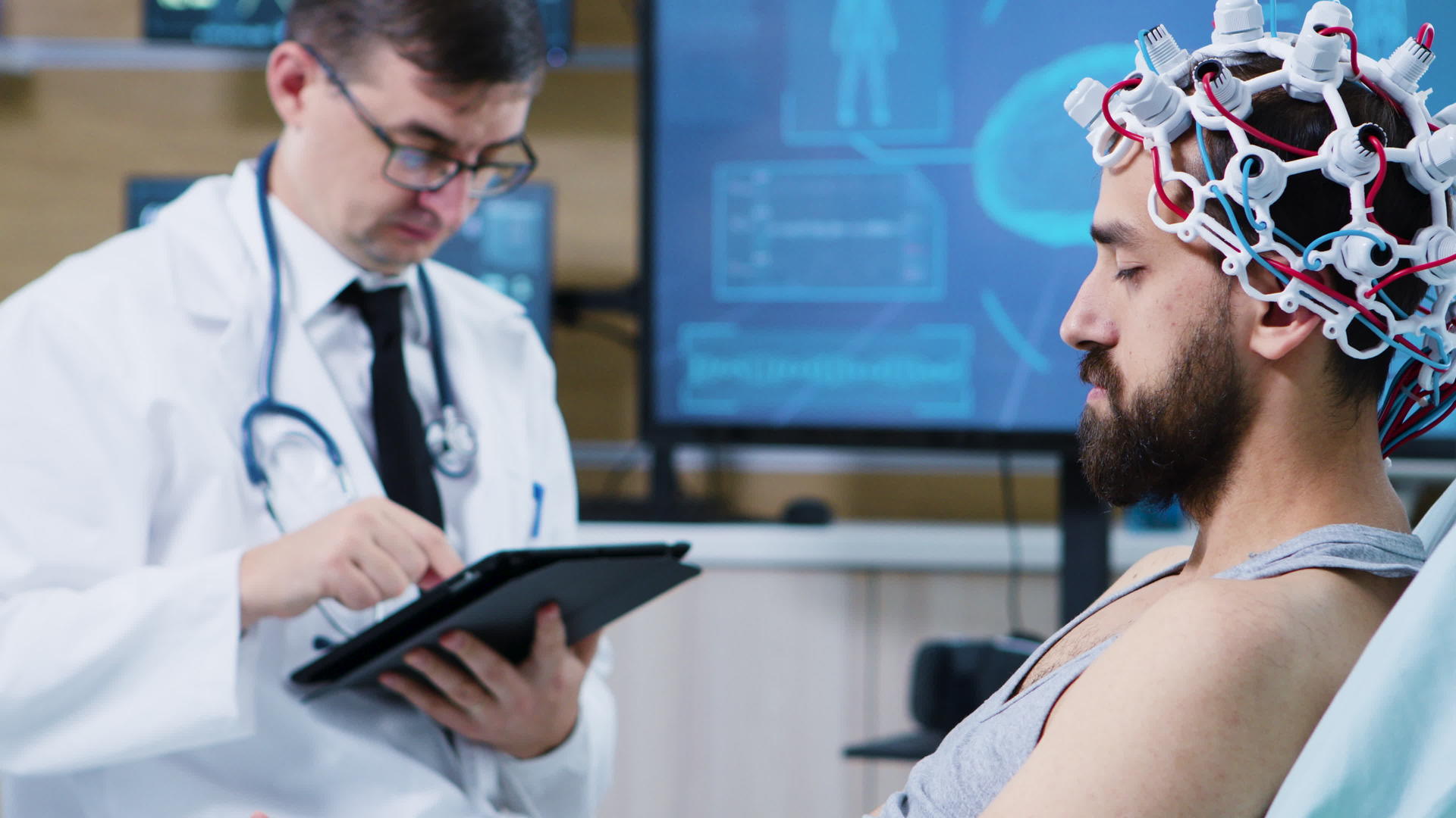 病人戴着脑电波扫描耳机坐在医院床上；视频的预览图