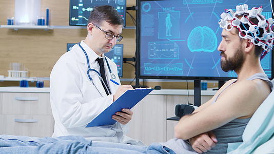 脑研究的医生坐在病人的床边在剪贴板上做笔记视频的预览图