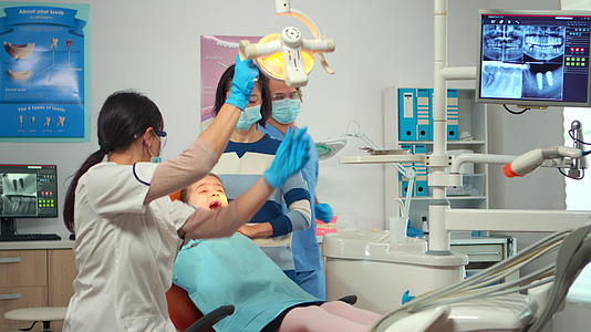 配备手套的牙医技术人员向儿童患者解释了这一过程视频的预览图