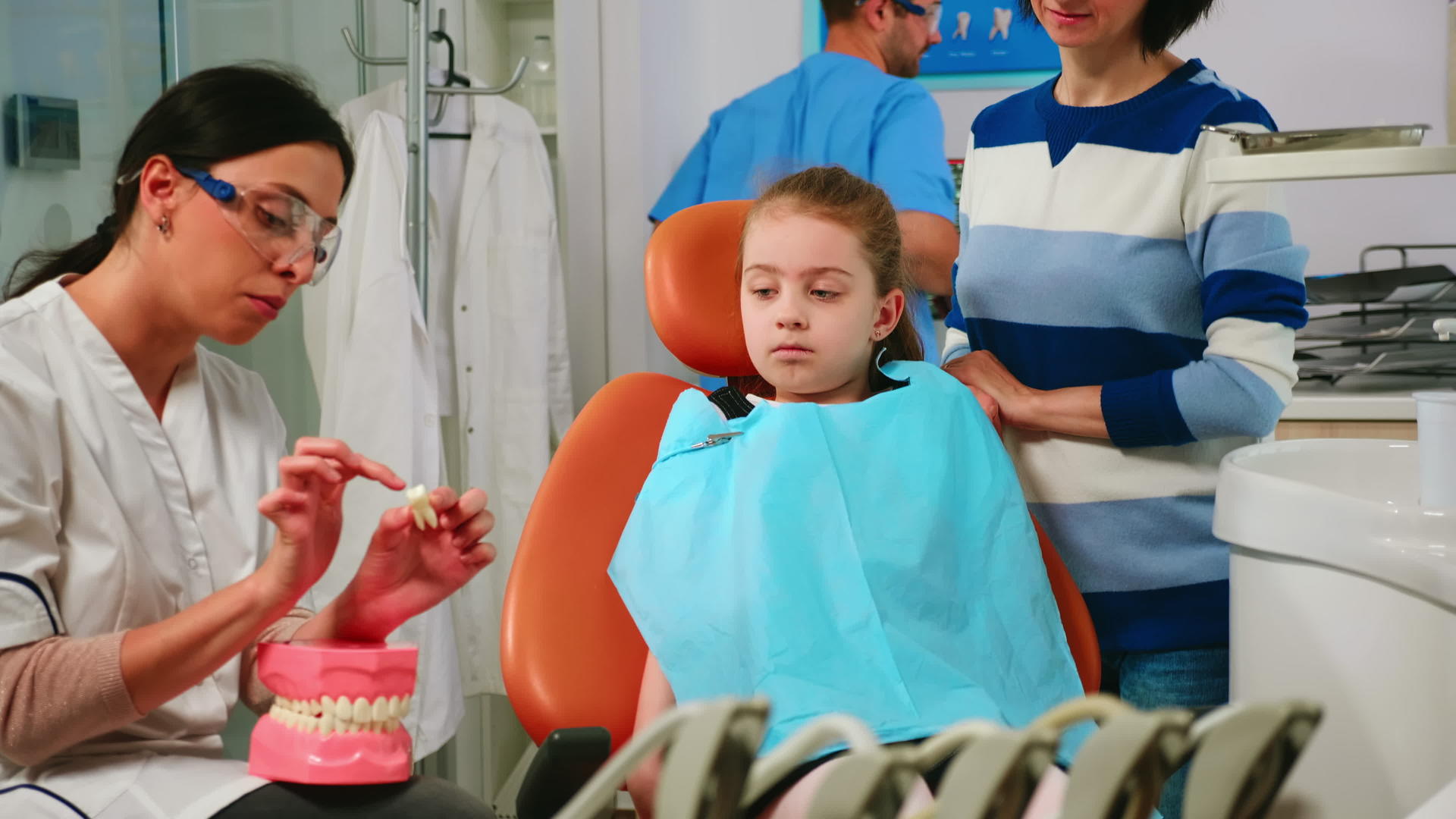 牙医向女孩解释了使用牙齿模型的程序视频的预览图