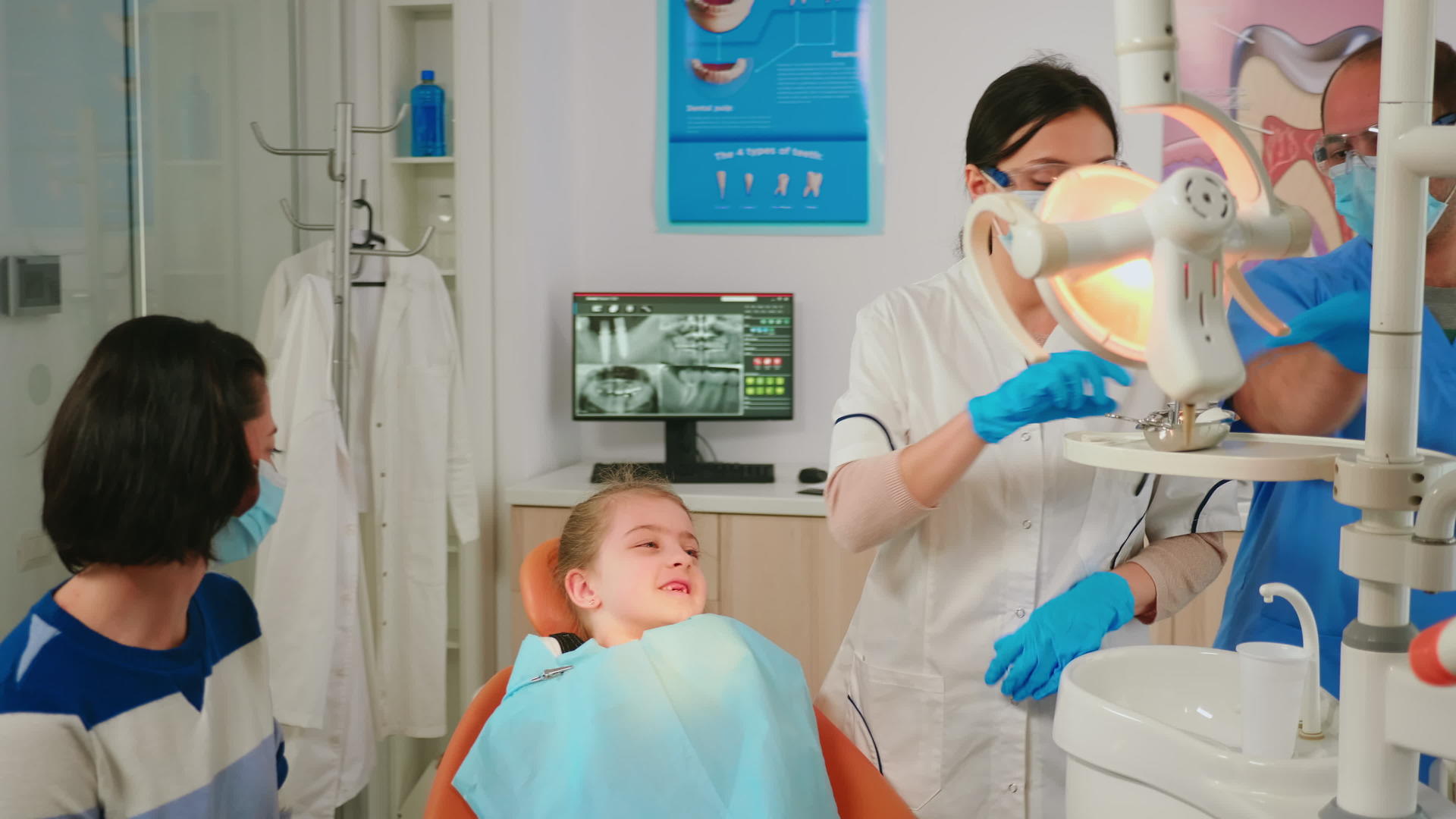 口腔医生病理学家持有绝育牙科工具与小病人交谈视频的预览图