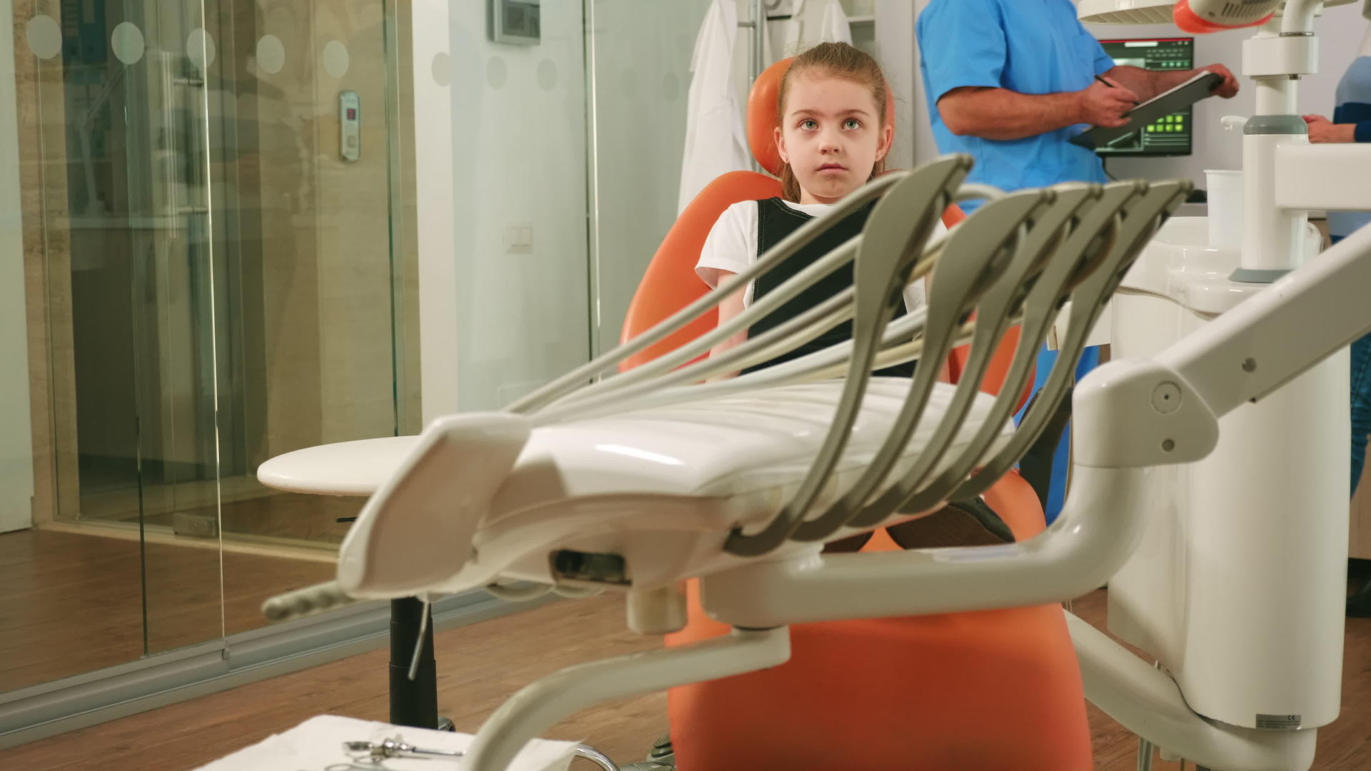 坐在牙科椅上等待儿科口腔医生的小女孩病人视频的预览图
