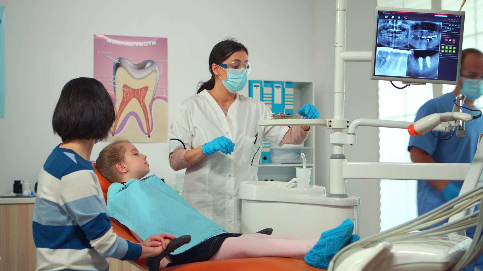儿科护士和牙医在现代牙科诊所工作为女孩提供治疗视频的预览图