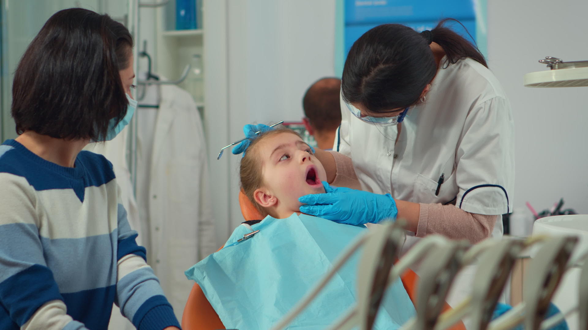 戴口罩的儿科牙医为小女病人治疗牙齿视频的预览图