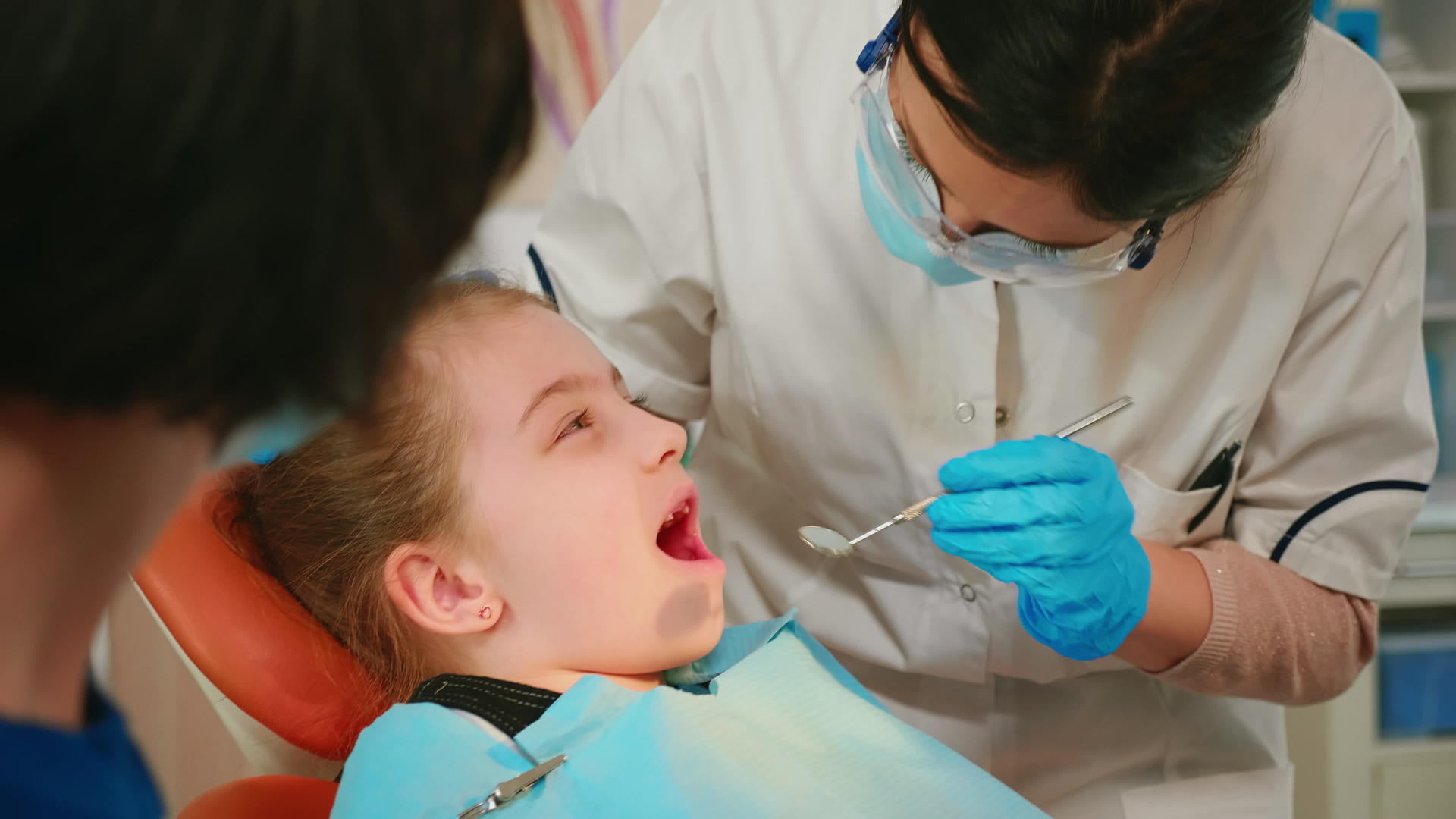 在牙科检查期间坐在椅子上张嘴的患者在口腔检查期间张嘴视频的预览图