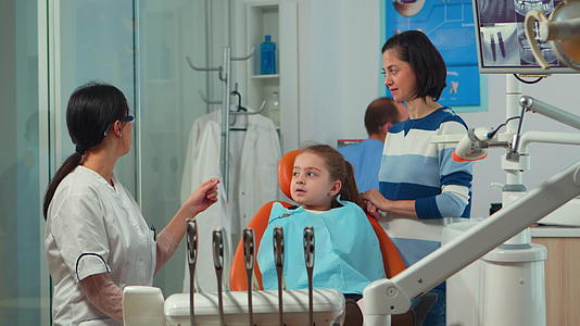 儿科女牙医在口腔诊所治疗小女孩；和；视频的预览图