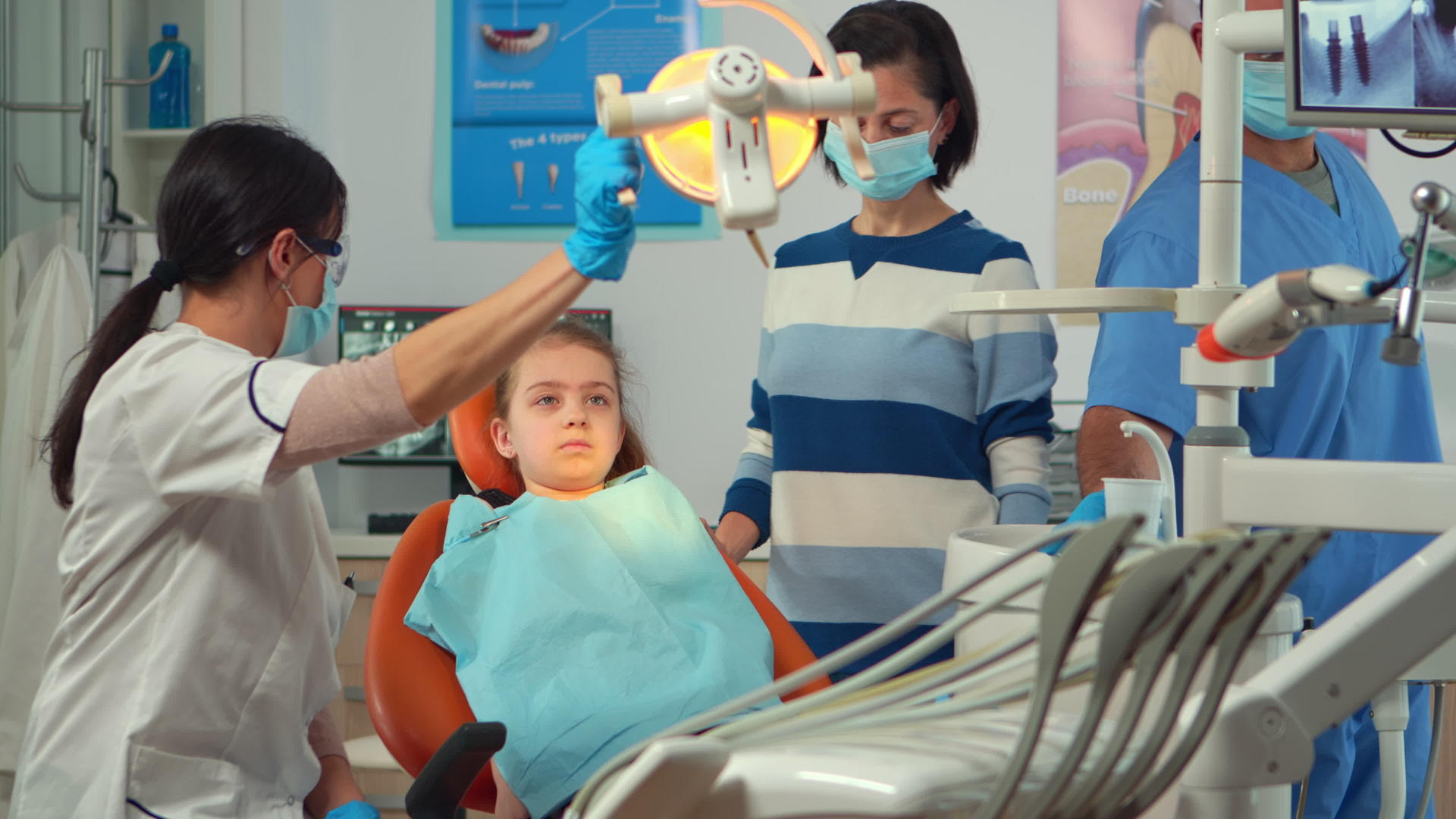 儿科牙医在牙科工作与护士和小女病人一起工作视频的预览图