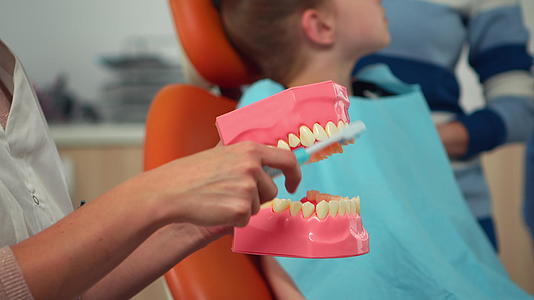 儿科牙医使用假骨显示正确的牙科卫生视频的预览图