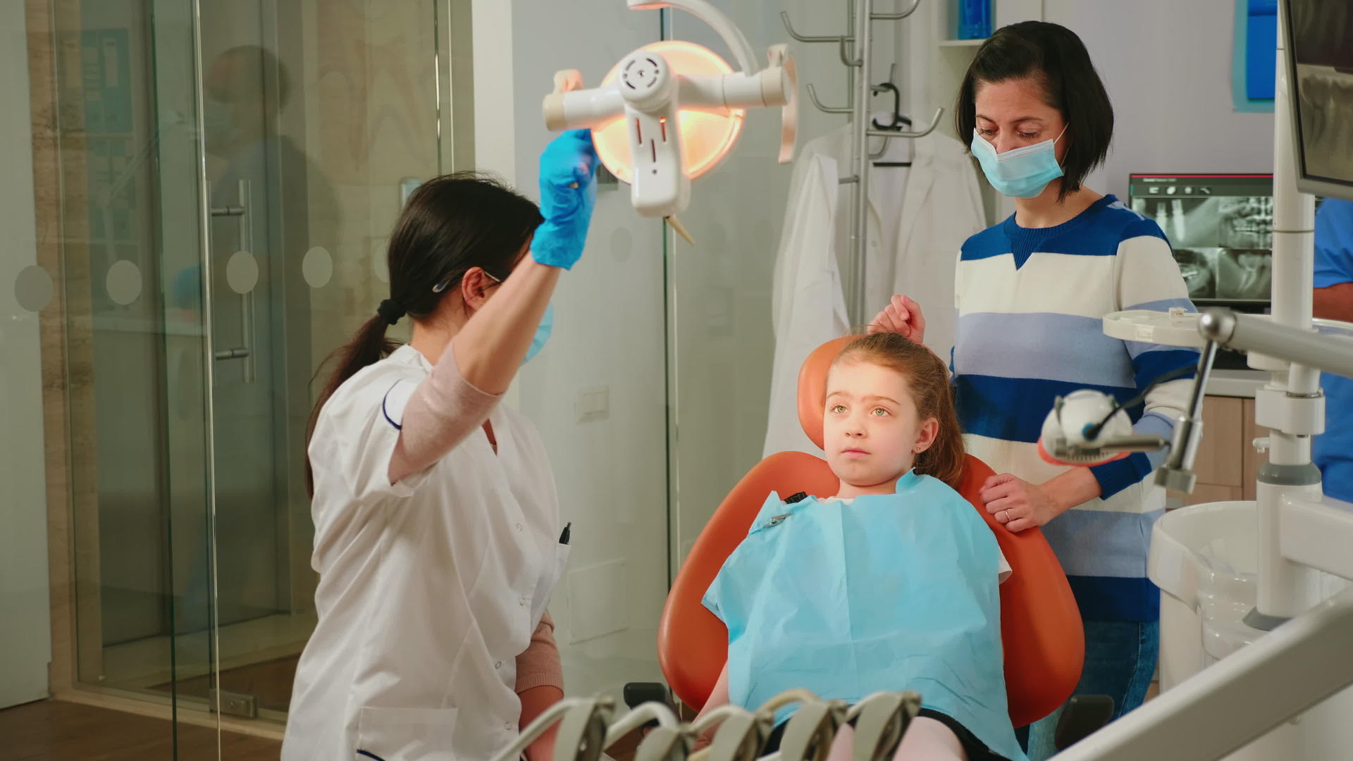 在口腔诊所接受治疗的儿科牙医和女性患者助理护士视频的预览图