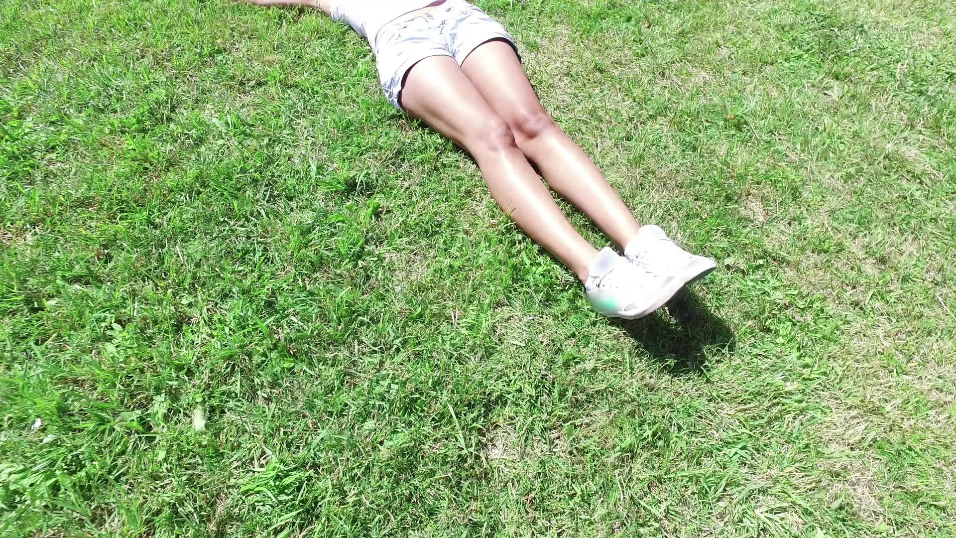 年轻、快乐、美丽的女孩躺在草地上视频的预览图