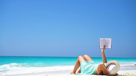 热带白沙滩期间年轻女性阅读书籍和书籍视频的预览图