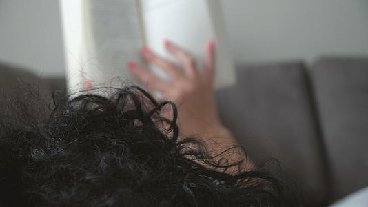 女性下班后在床上看书放松疲惫的双腿视频的预览图