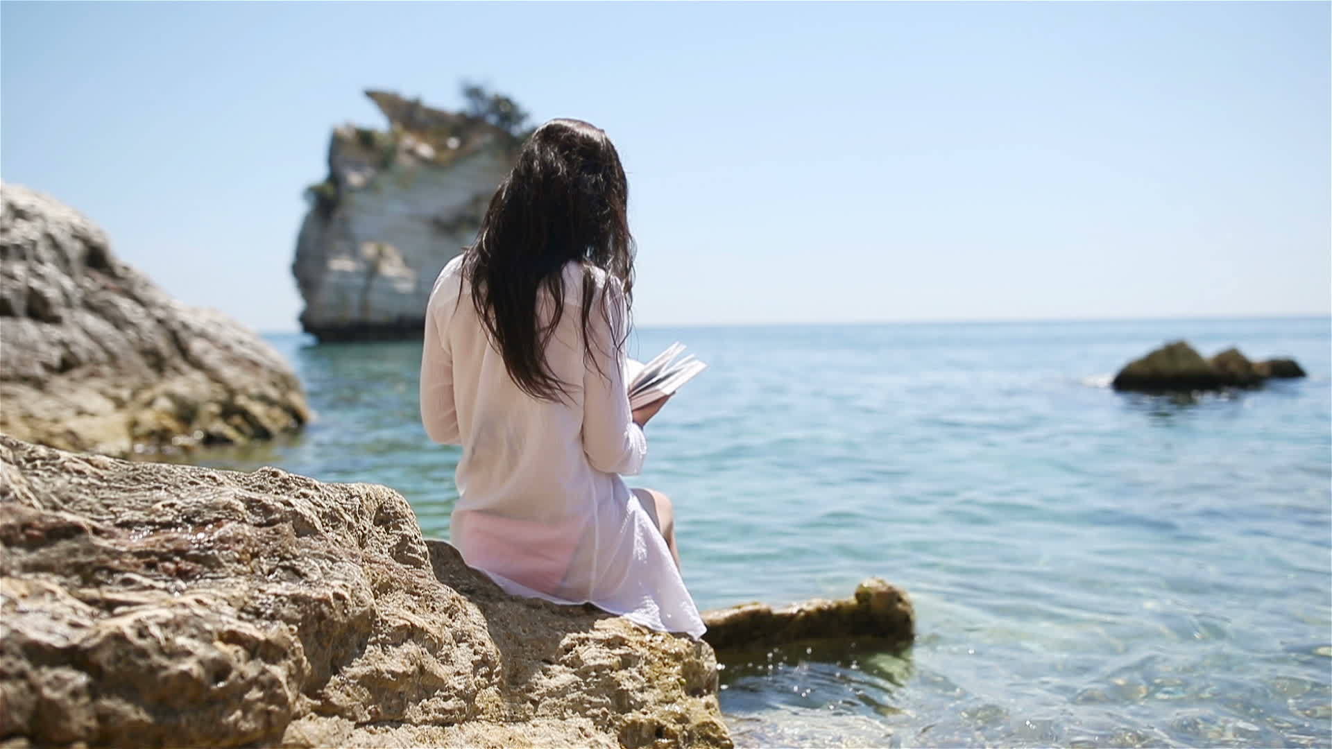 年轻女性在热带白色沙滩上阅读视频的预览图