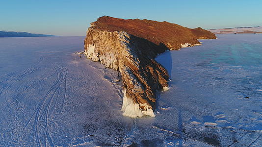 冰冻的贝加尔湖被冰雪覆盖着高大的岩石和悬崖鸟瞰图视频的预览图