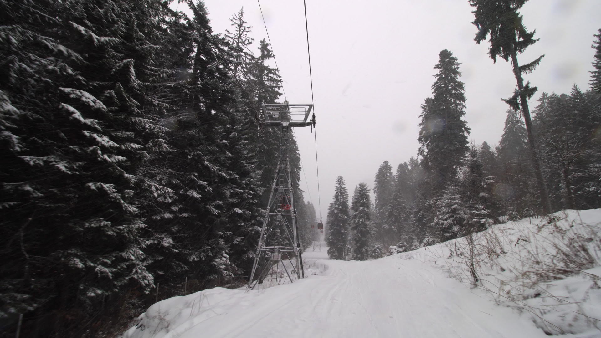 下雪时小木屋在滑雪中心升起冬天移动到冬天Gondolas视频的预览图