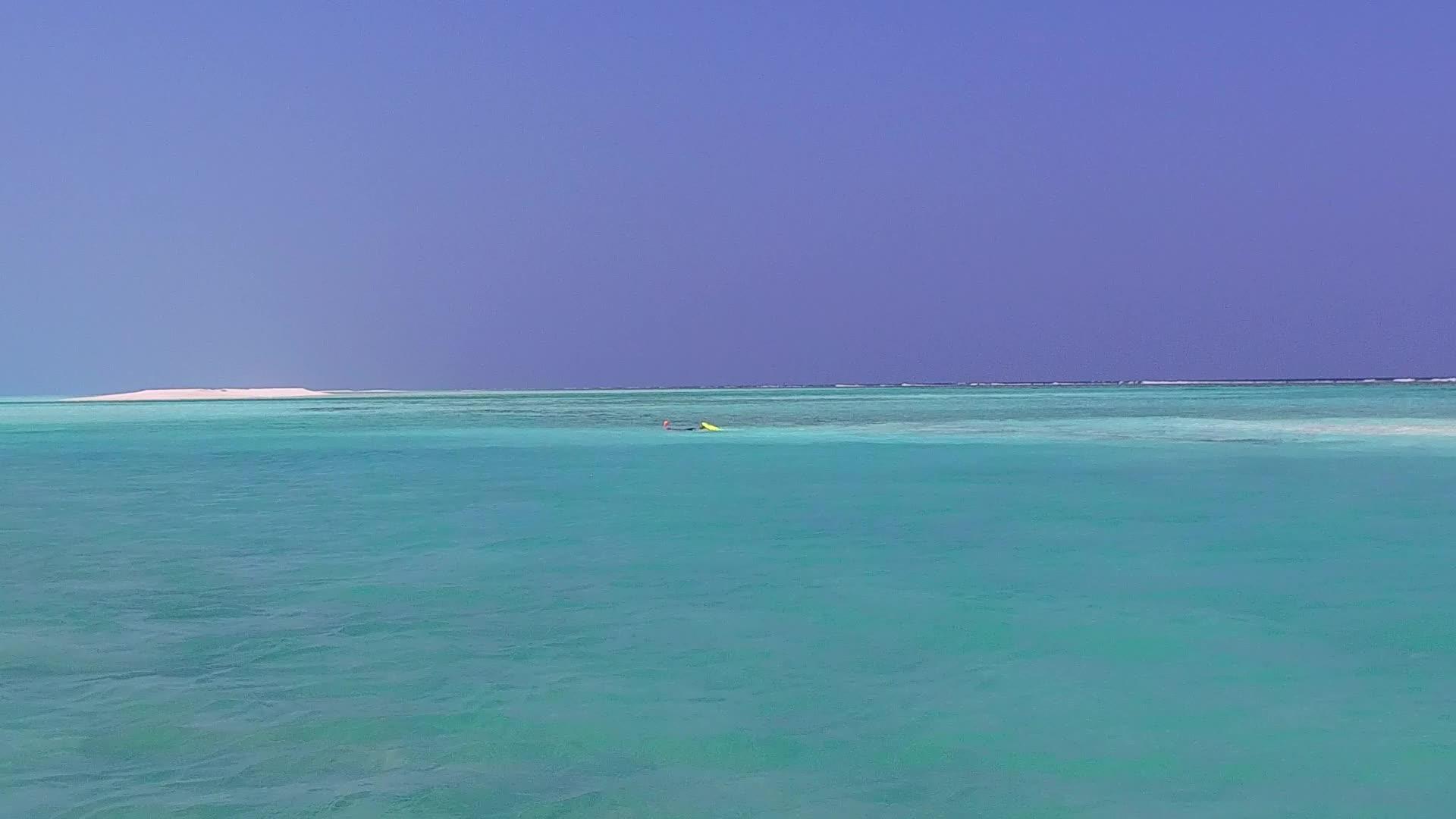 蓝色海洋和冲浪附近浅沙背景的美丽景观包括完美的环礁视频的预览图