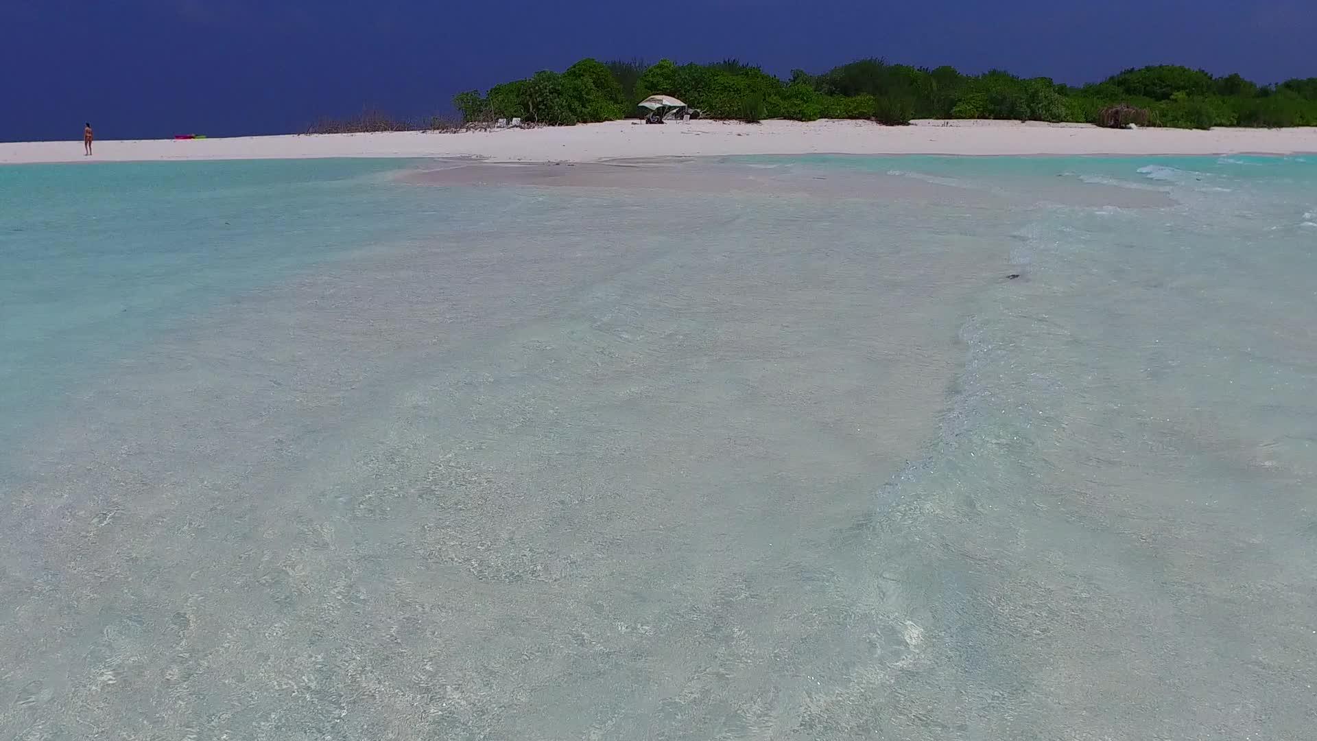明亮的海洋和接近冲浪的浅沙背景阳光明媚的天气视频的预览图
