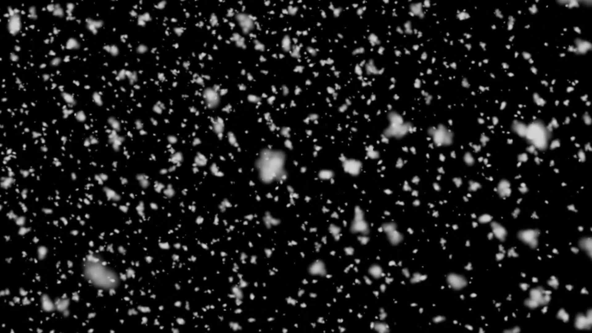 黑色背景下从顶部掉落的大片雪碎片hd视频的预览图
