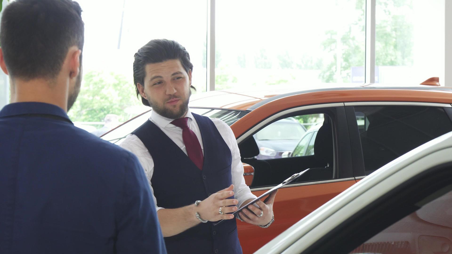 帅帅男汽车经销商与男客户交谈视频的预览图