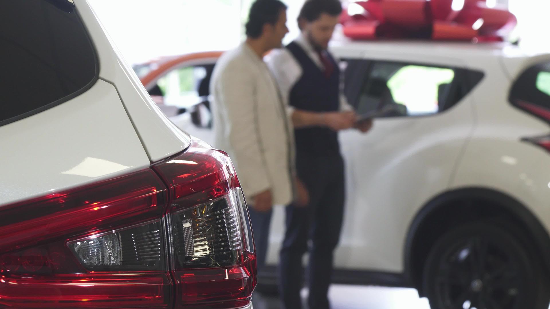 专业汽车销售人员向男性客户展示汽车视频的预览图