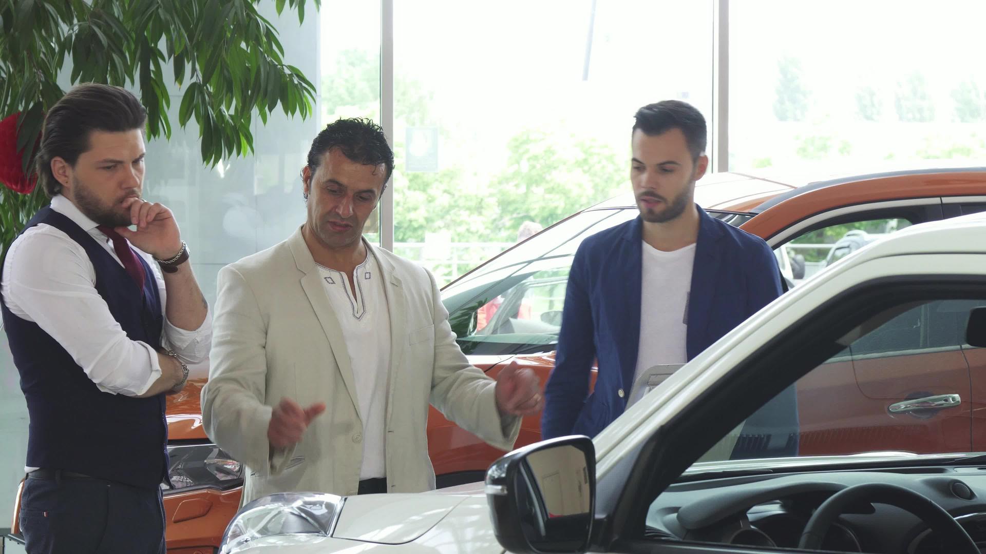 三个男性朋友在经销店检查汽车销售情况视频的预览图