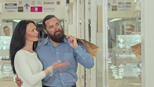 一对快乐的成熟夫妇在商场里看着服装店视频的预览图