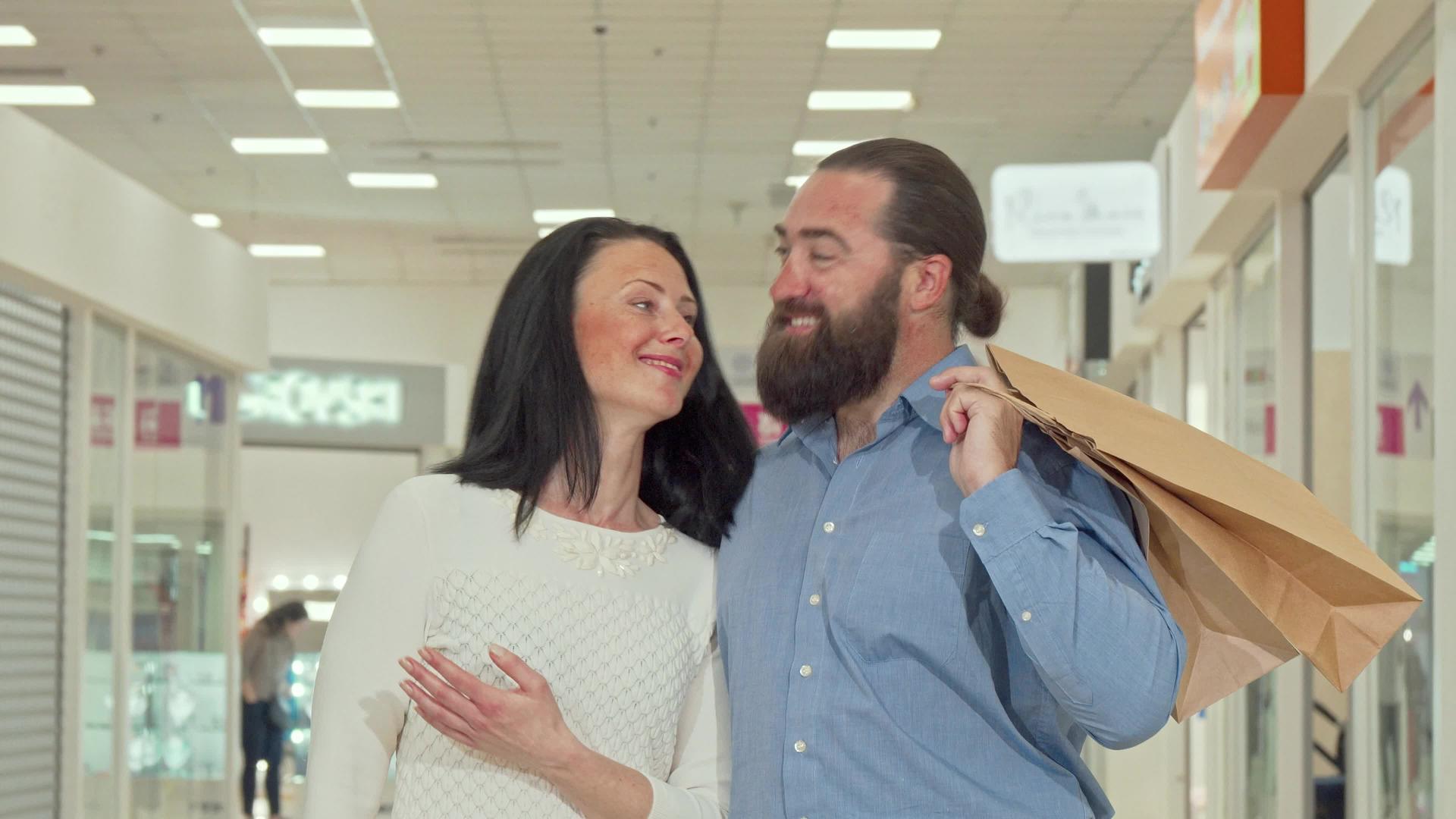 快乐成熟的情侣在当地商场享受季节性销售视频的预览图