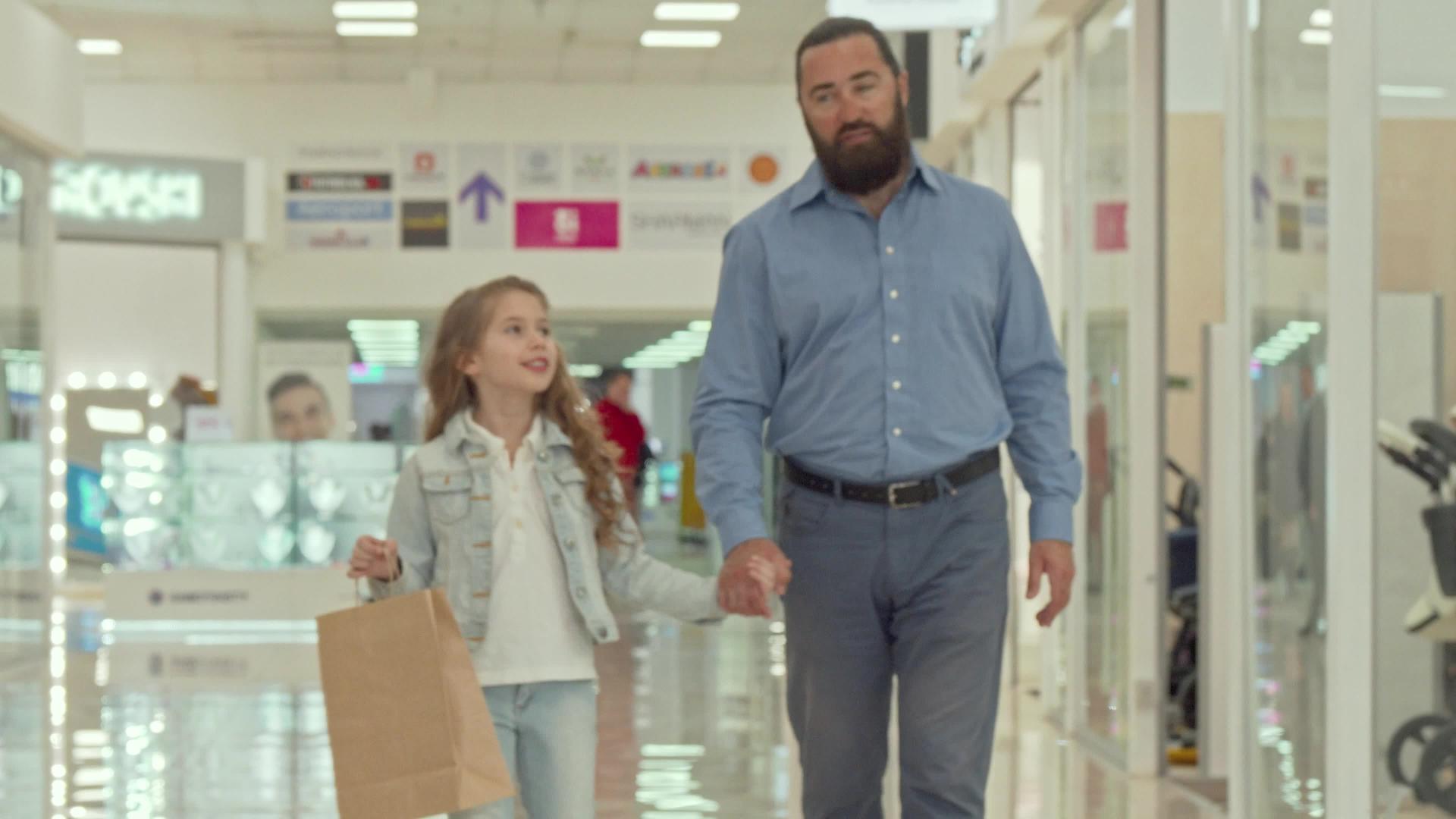 这位慈爱的父亲带着他可爱的小女儿在购物中心散步视频的预览图
