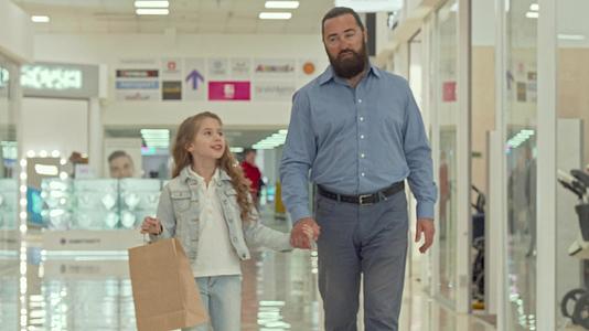这位慈爱的父亲带着他可爱的小女儿在购物中心散步视频的预览图
