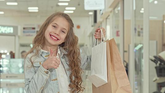 可爱可爱的小女孩在购物中心露出拇指视频的预览图