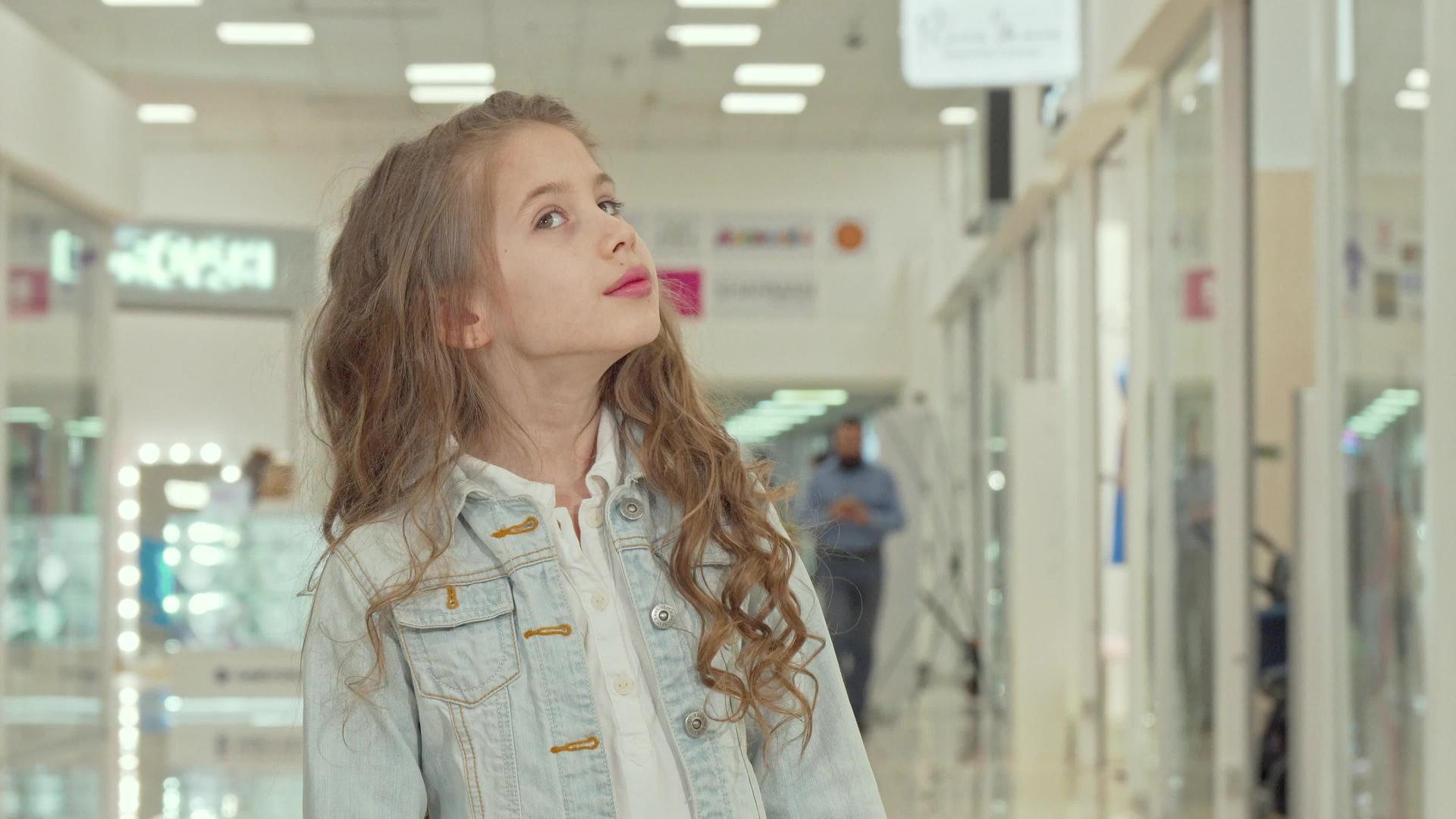 可爱的小女孩在购物中心的相机上微笑着视频的预览图