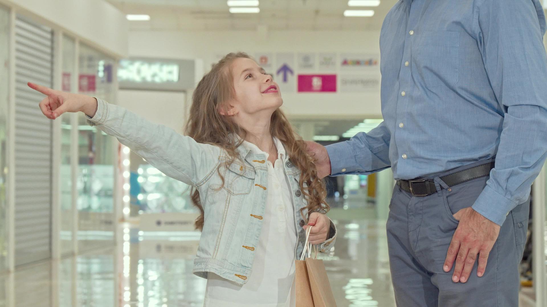 快乐的小女孩和她的父亲在购物中心购物视频的预览图
