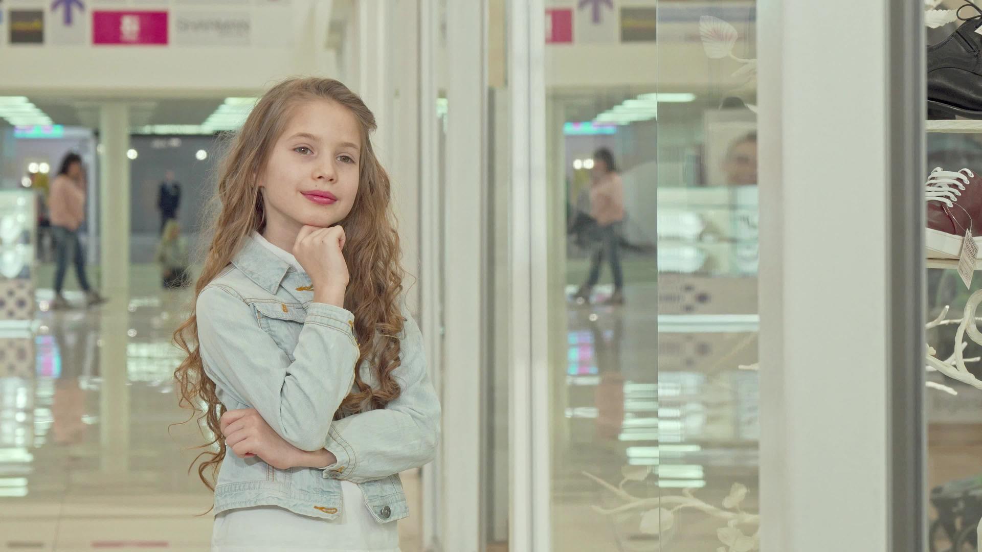 可爱的小女孩对着镜头微笑检查时装店视频的预览图
