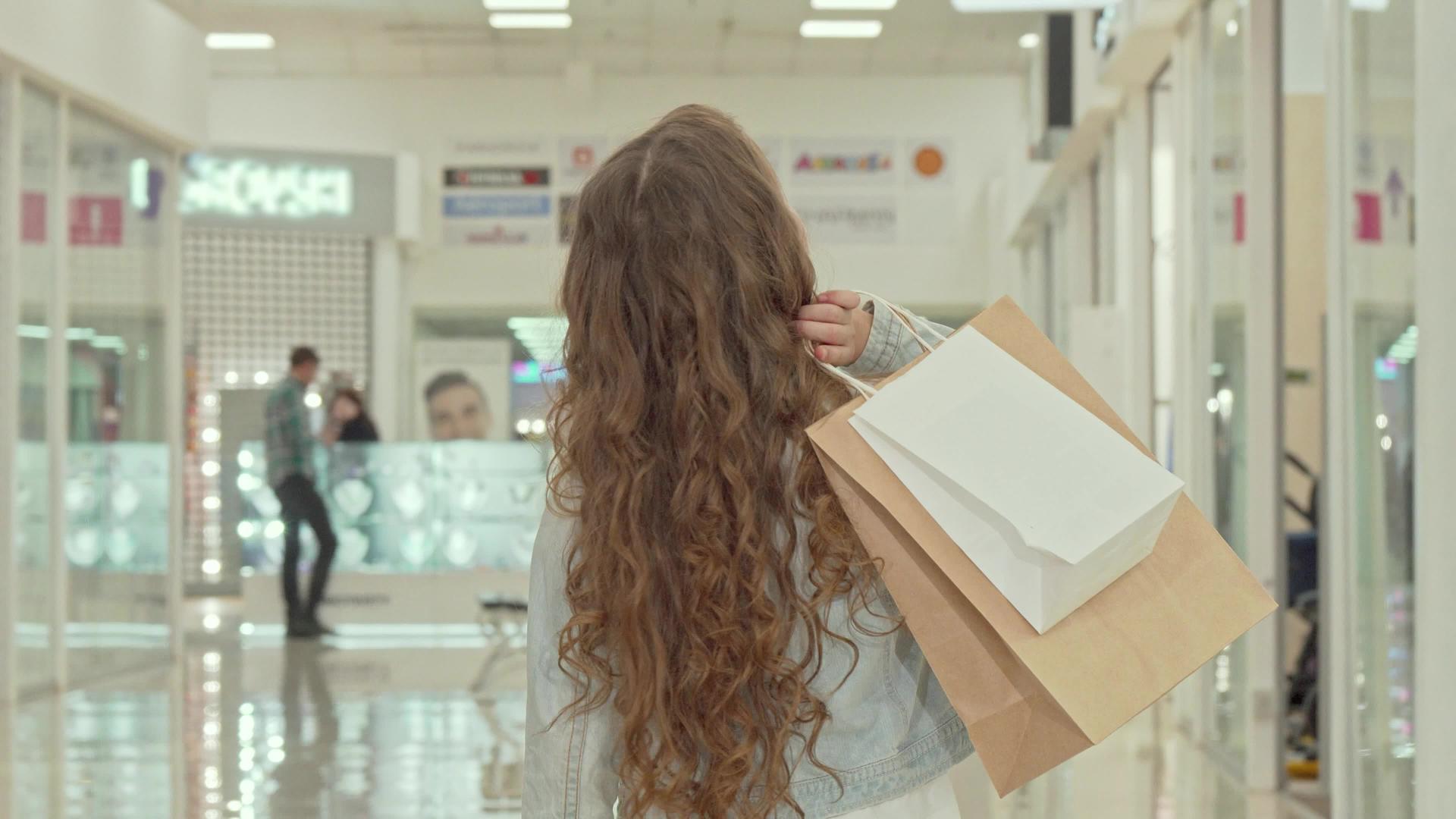 一个卷发的小女孩在商场看服装店时被一个卷发的小女孩拍到视频的预览图